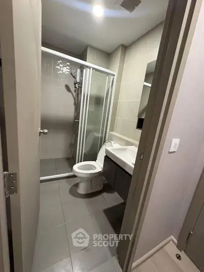 Modern bathroom with glass shower and sleek fixtures in a contemporary apartment.