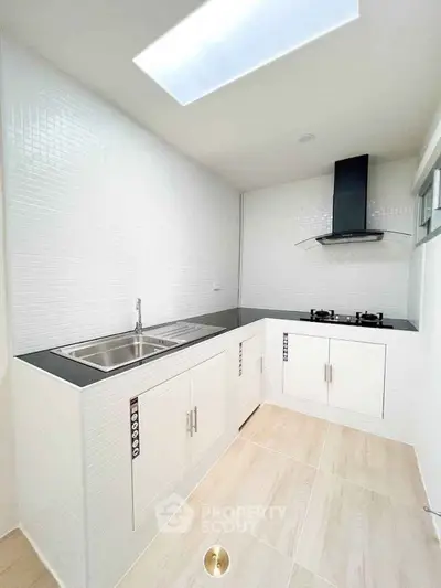 Modern kitchen with sleek design, featuring gas stove and ample storage space.