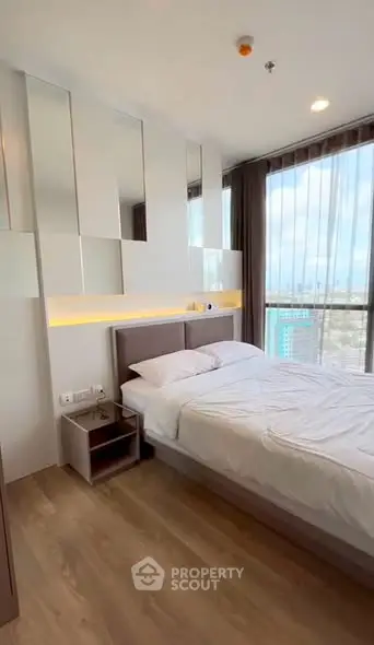 Modern bedroom with floor-to-ceiling windows and stylish decor in a high-rise apartment.