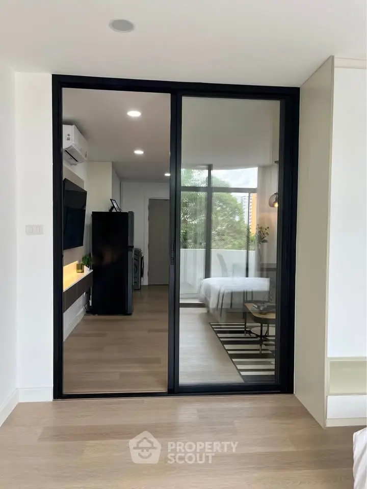 Modern apartment interior with sliding glass doors, sleek design, and natural light.
