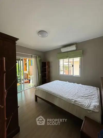 Spacious bedroom with balcony access and natural light