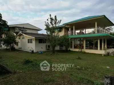 Spacious two-story house with large balcony and lush garden, perfect for family living.