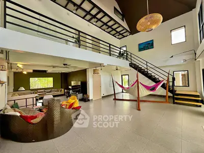 Spacious modern living room with mezzanine, stylish decor, and hammock for relaxation.