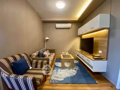 Modern living room with stylish furniture and wall-mounted TV