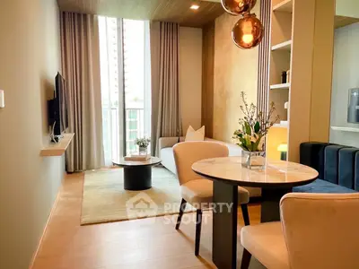 Modern living room with elegant decor and natural light, featuring a cozy seating area and stylish lighting.