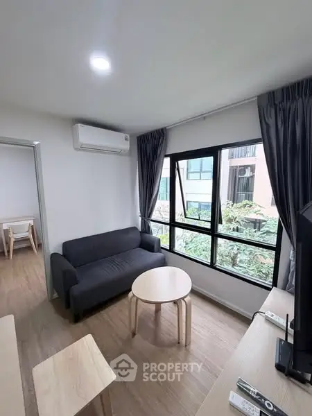 Modern living room with large window and cozy sofa in a stylish apartment.