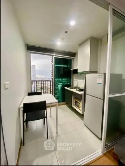 Modern kitchen with city view, featuring sleek appliances and dining area in a compact layout.