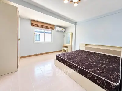Spacious bedroom with natural light and modern furnishings