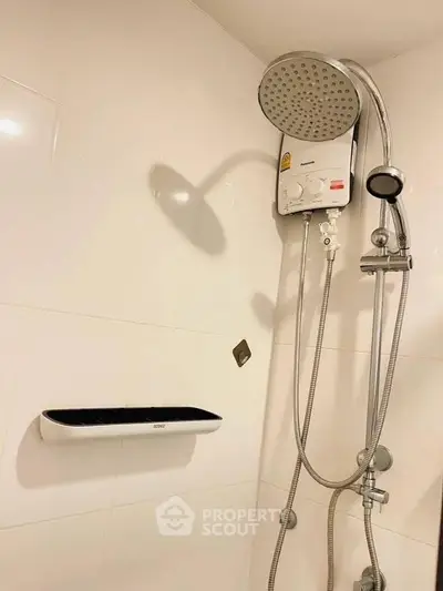 Modern bathroom with sleek showerhead and white tiled walls, perfect for a refreshing experience.