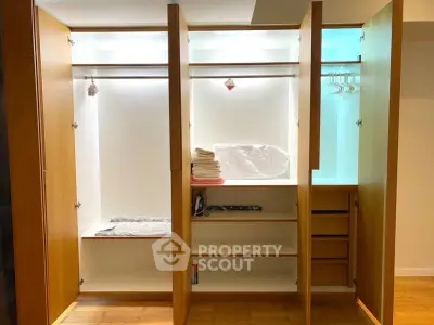 Spacious walk-in closet with wooden shelves and ample storage space.