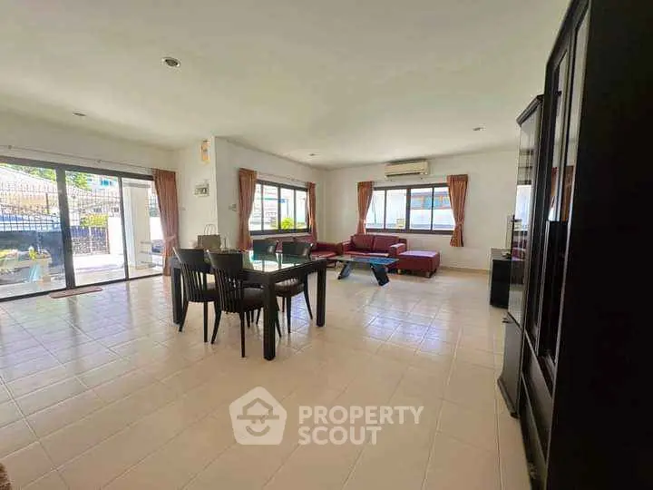 Spacious open-plan living and dining area with modern furnishings and large windows.