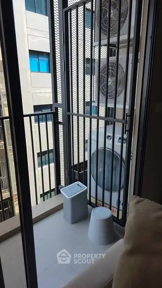 Modern balcony with air conditioning units and seating area in urban apartment