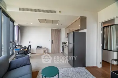 Modern open-plan living room with kitchen and study area, featuring sleek design and natural light.