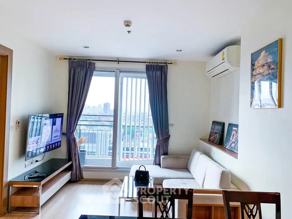 Modern living room with city view, featuring sleek furniture and large windows for natural light.