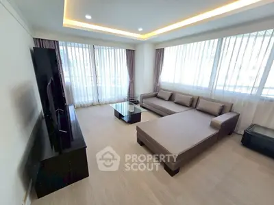 Spacious modern living room with large windows and elegant furniture