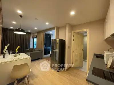 Modern open-layout kitchen and living room with stylish decor and bright lighting.