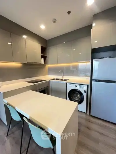 Modern kitchen with sleek cabinetry, built-in appliances, and cozy dining area.