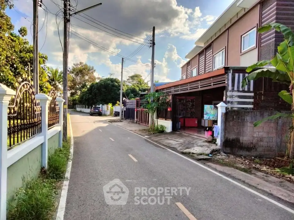 Charming suburban street view with modern townhouse and lush greenery, perfect for serene living.