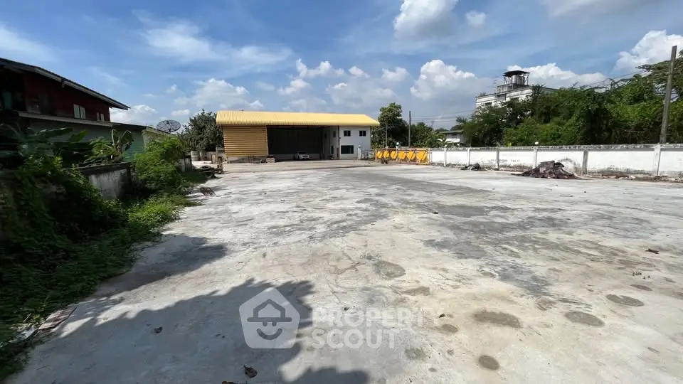 Spacious industrial property with large open concrete yard and warehouse.