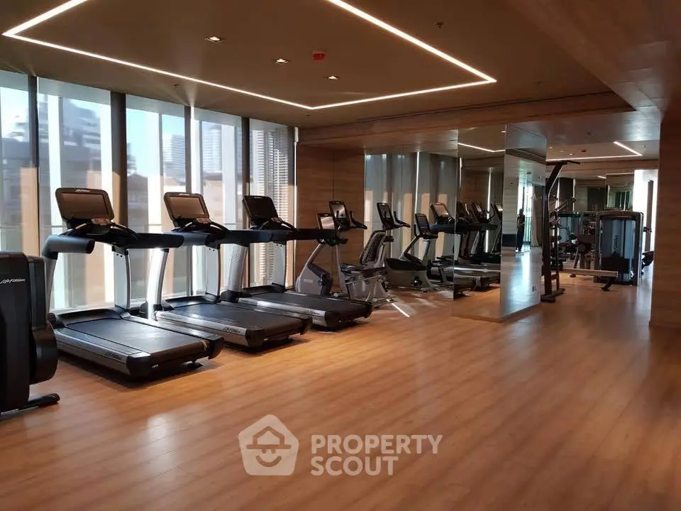 Modern gym with treadmills and exercise equipment in luxury building