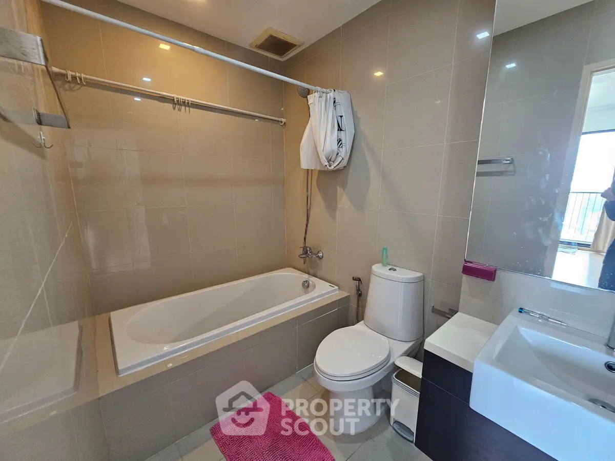 Modern bathroom with bathtub and sleek fixtures in a contemporary apartment.