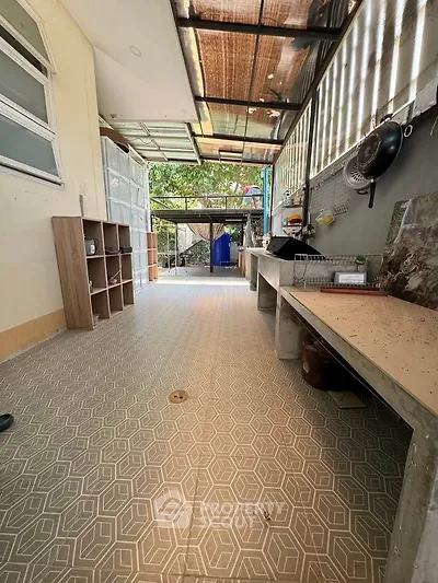 Spacious outdoor kitchen area with tiled flooring and natural light, perfect for entertaining.