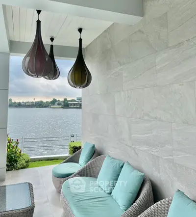 Luxurious balcony with stylish seating and stunning waterfront view.