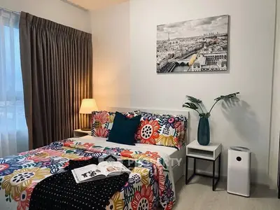 Cozy bedroom with vibrant bedding and cityscape artwork, perfect for modern living.