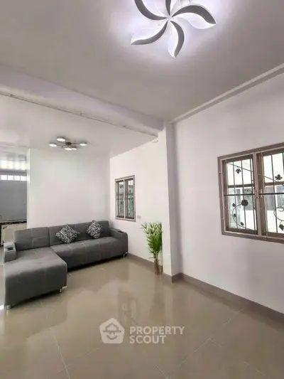 Modern living room with stylish gray sofa and elegant ceiling light fixture.