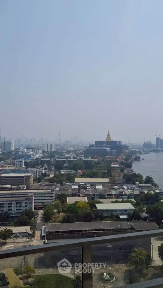 Stunning cityscape view from a high-rise balcony overlooking urban skyline and river.