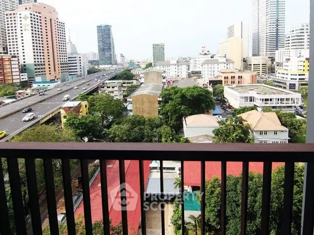 Stunning cityscape view from a high-rise balcony overlooking urban skyline and lush greenery.