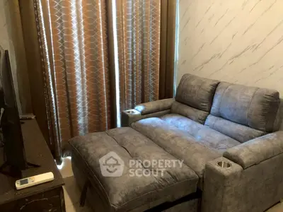 Cozy living room with plush gray sofa and elegant curtains, perfect for relaxation.