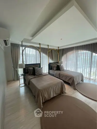 Luxurious bedroom with twin beds and floor-to-ceiling windows for natural light.