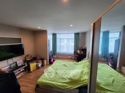 Spacious bedroom with modern decor and large windows for natural light.