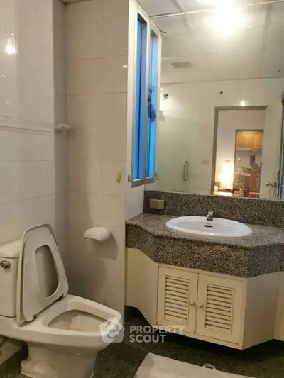 Modern bathroom with sleek design and granite countertop in a contemporary home.