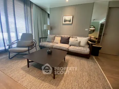 Modern living room with stylish furniture and natural light through large windows.