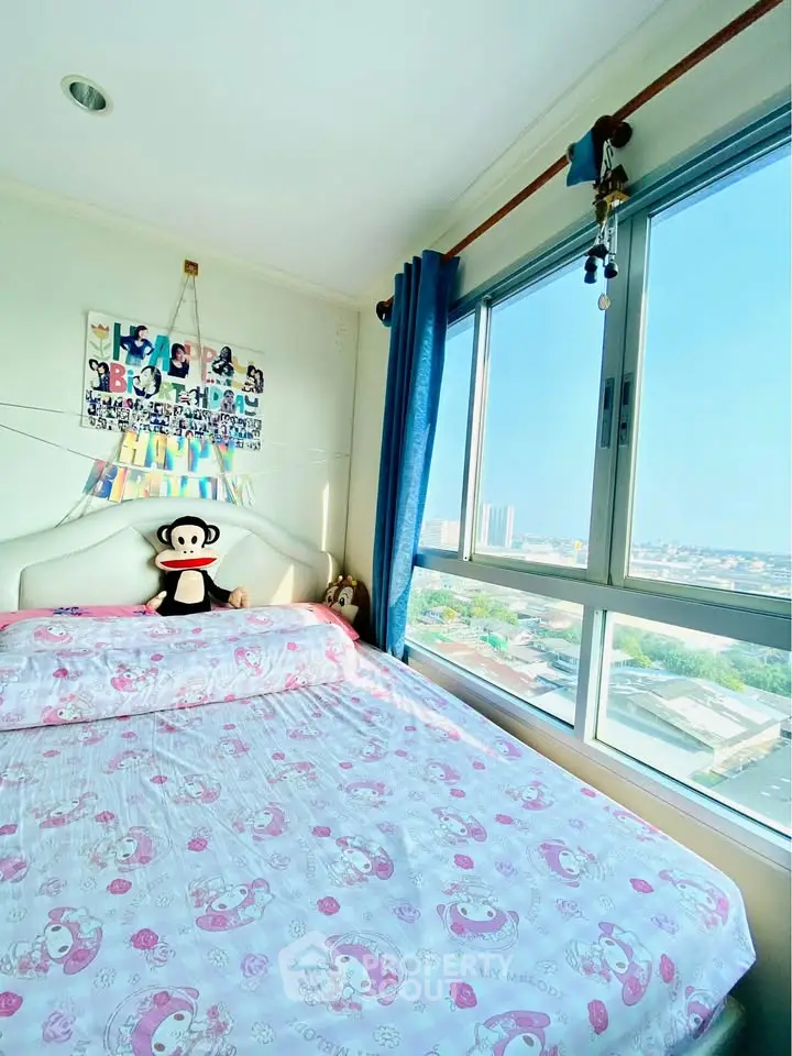 Bright bedroom with large window offering stunning city views, featuring cozy decor and plush bedding.