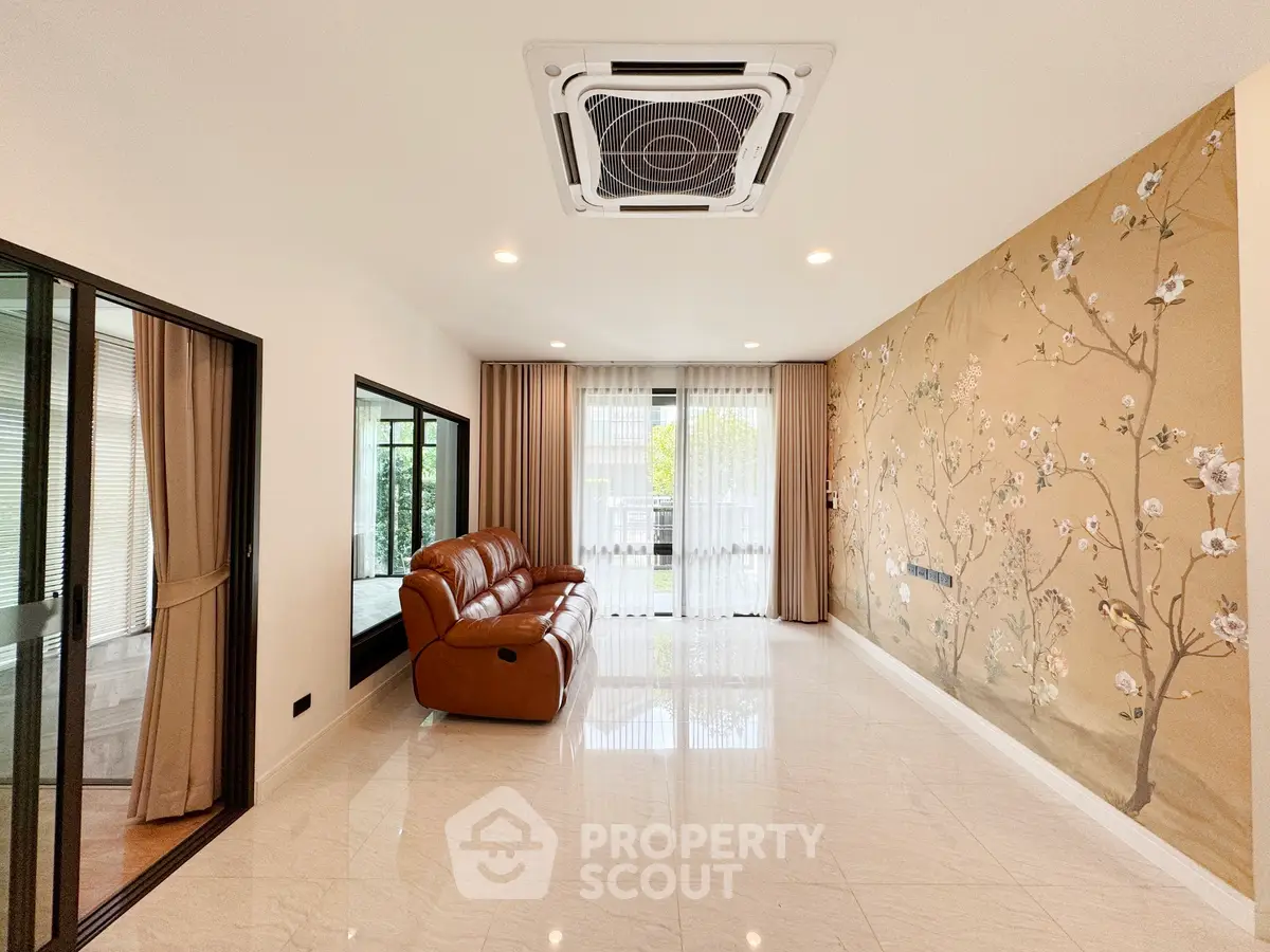 Spacious living room with elegant floral accent wall and modern air conditioning.
