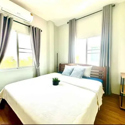 Bright and cozy bedroom with large windows and modern decor, perfect for relaxation.