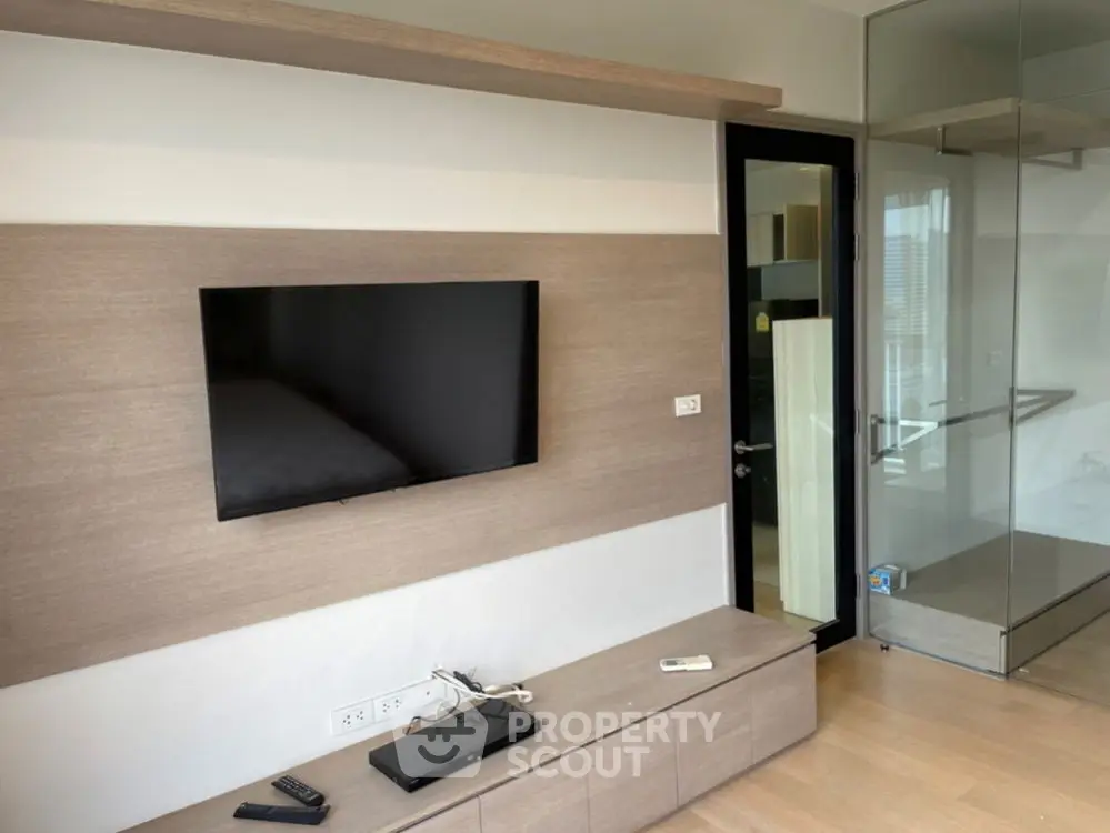 Modern living room with wall-mounted TV and sleek wooden cabinetry