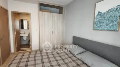 Modern bedroom with ensuite bathroom and stylish decor in a contemporary apartment.