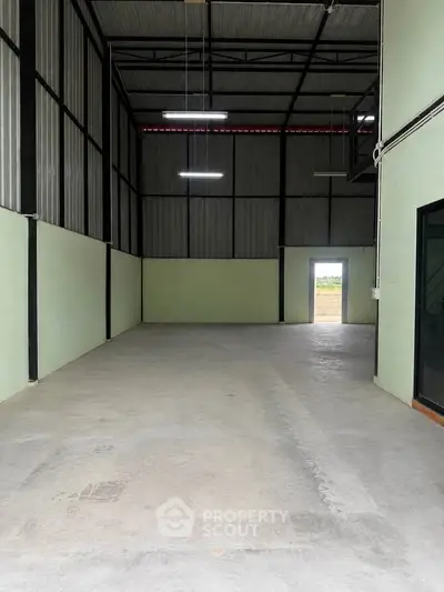 Spacious industrial warehouse with high ceilings and ample natural light, perfect for storage or manufacturing needs.