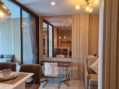 Modern open-plan living and dining area with stylish lighting and wooden accents.