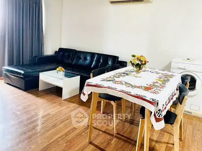 Spacious living room with modern furniture and dining area, featuring a washing machine for convenience.