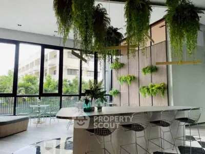 Modern kitchen with sleek design and open layout, featuring a stylish breakfast bar and lush greenery.