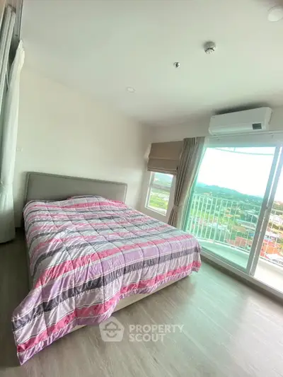 Spacious bedroom with large window offering stunning views and natural light.