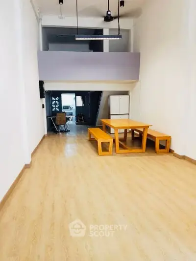 Spacious modern living area with wooden flooring and minimalist furniture, ideal for urban living.