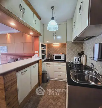 Charming kitchen with modern appliances and open layout, featuring stylish cabinetry and cozy lighting.