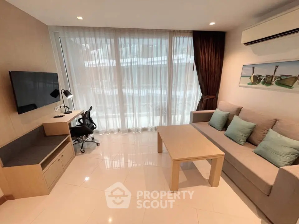 Modern living room with sleek furniture and natural light, featuring a cozy sofa and work desk.