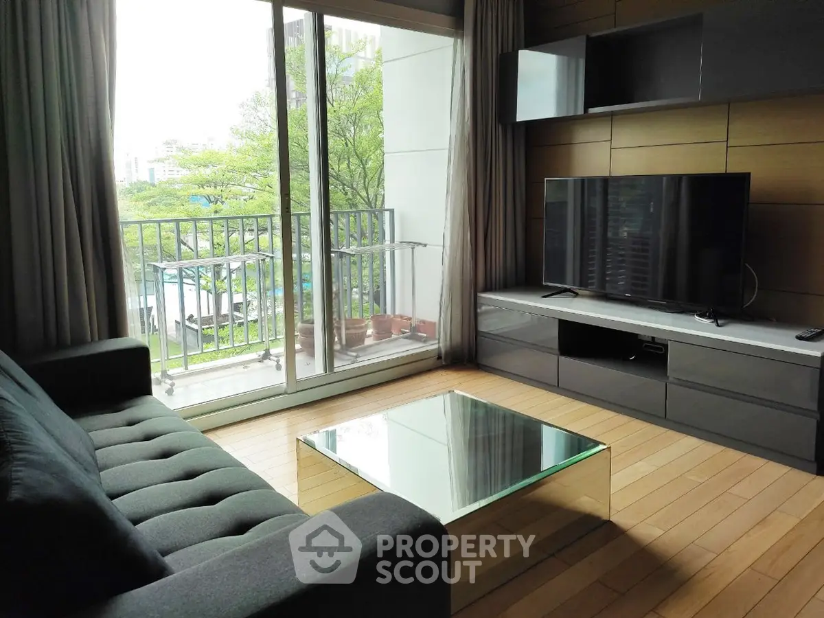 Modern living room with glass coffee table and balcony view in urban apartment